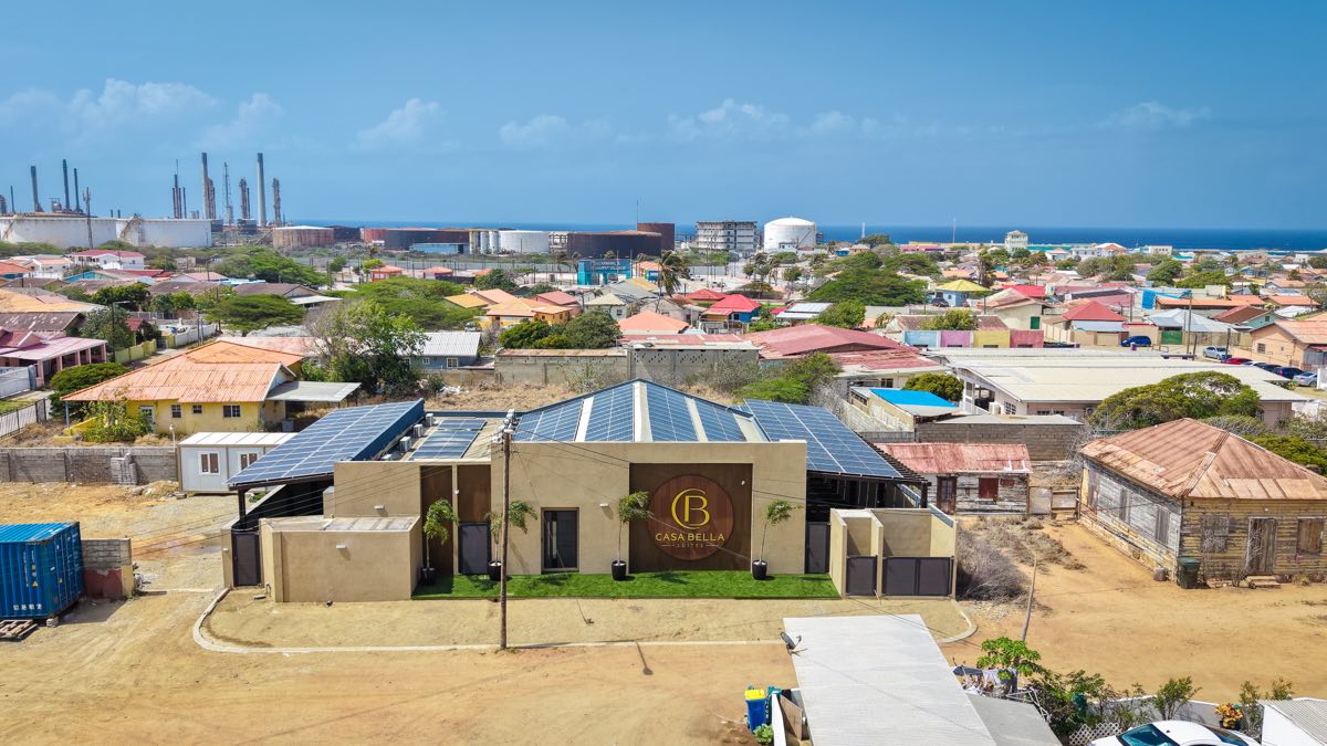Casabella Suites seen from the air above San Nicolas, with the town, the old refinery and the sea beyond.